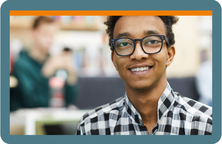 Teenager with glasses in a classroom.