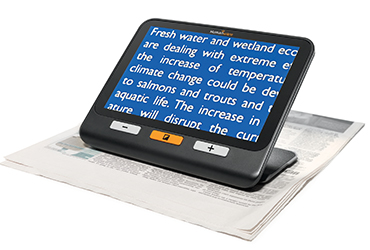 Image of exploré 8 on its built-in stand showing the white text on a blue background color contrast option to read a newspaper.