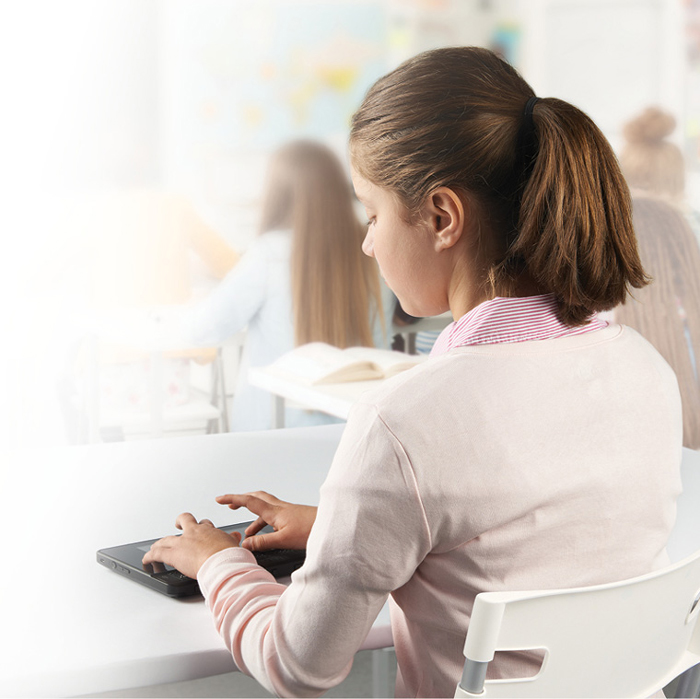 Photo montrant une jeune étudiante avec le BrailleNote en classe.