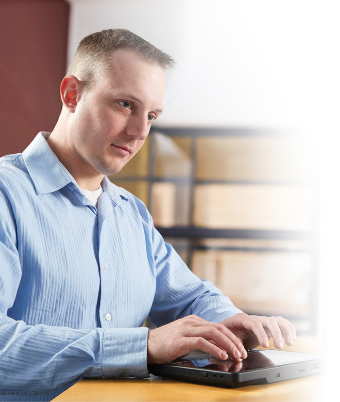 Picture of a man working with the BrailleNote Touch at a coffee shop