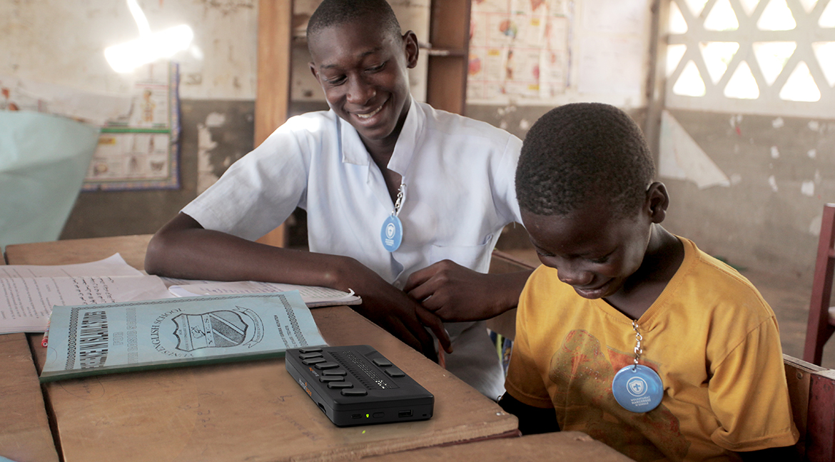 Two young students in the classroom, one of them is using BrailleOne. Two young students in the classroom, one of them is using BrailleOne.