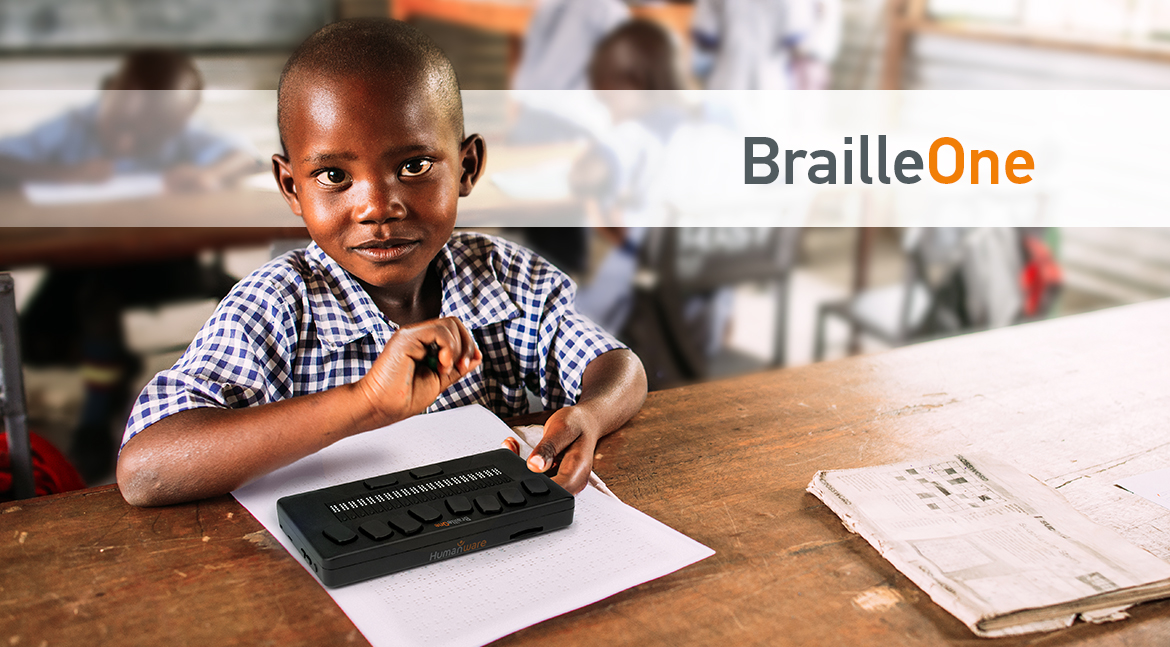 A young blind boy using BrailleOne in the classroom. We read the name of the product BrailleOne. A young blind boy using BrailleOne in the classroom. We read the name of the product BrailleOne.