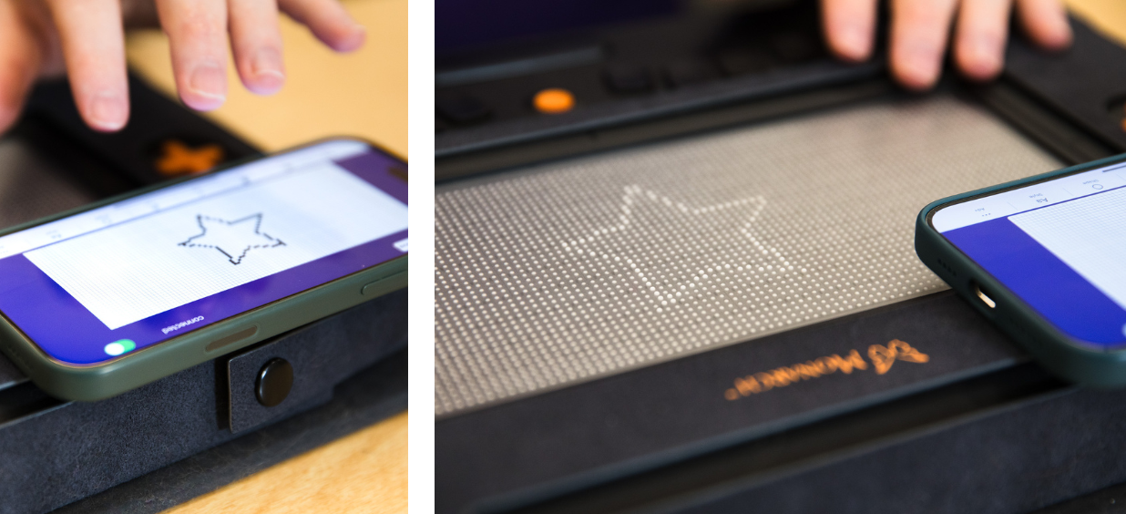 Hands using the Monarch tactile display showing a star shape synced with a smartphone.