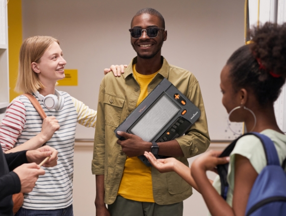 The picture shows a group of people in discussion, one holding the Monarch in his hands.