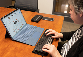 Maryse using a Microsoft Surface paired with a BIX 40 braille display.