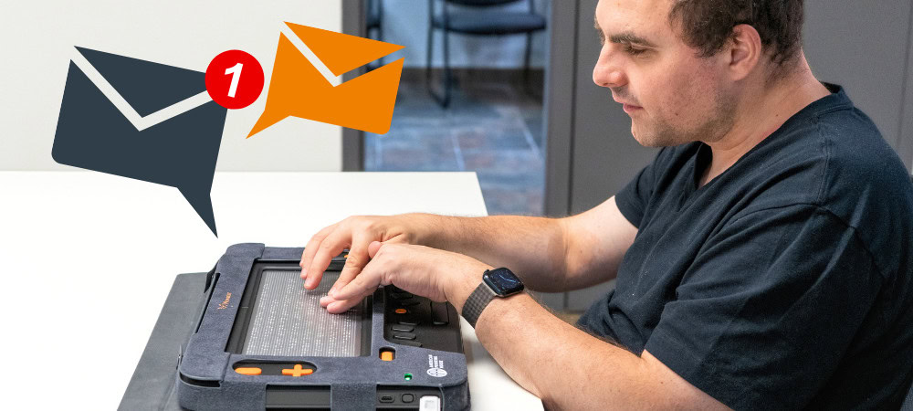 Image of a focused man uses the Monarch device to read his e-mails, with message notification icons visible at the top of the image.