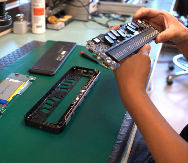 Une Personne vérifie et assemble les composants mécaniques et électroniques du Brailliant BI 40X.