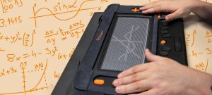 A person is using the Monarch, a tactile graphics display device, to read mathematical content through touch. The background shows various mathematical equations and graphs in orange on a beige surface.