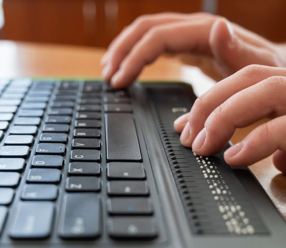 A blind student uses a computer with the Mantis Braille display.
