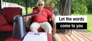 An elderly man relaxes while listening to the Odyssey voice reading his favorite magazine.