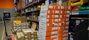 Stacks of HumanWare boxes neatly arranged in a warehouse.