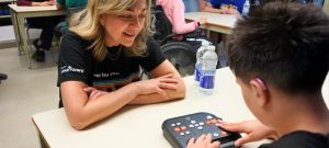 A smiling HumanWare employee supports a hearing-impaired student using a Stratus.