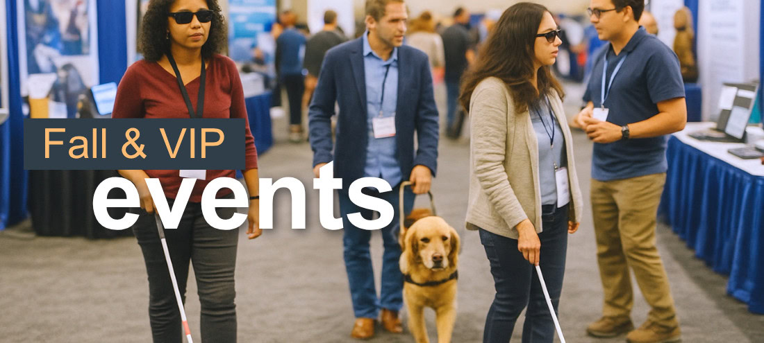 Blind people with white canes and a guide dog at an event.