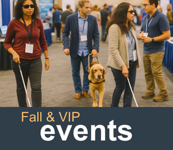 Blind people with white canes and a guide dog at an event.
