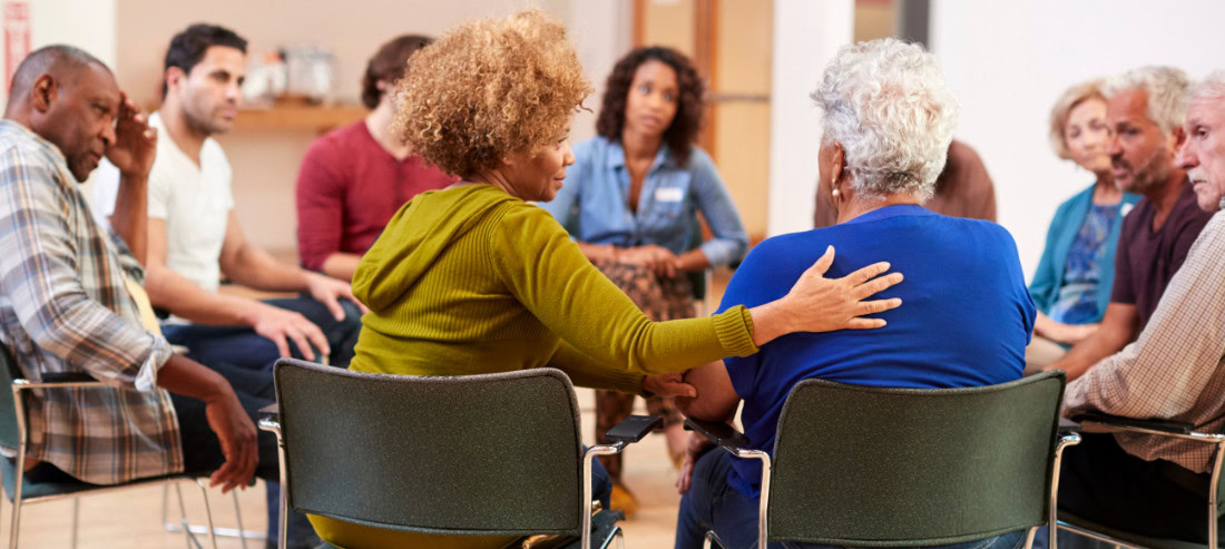 Support group participants sitting in a circle during a community discussion session.