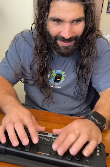 Anthony Ferraro using assistive technology to perform workplace tasks independently.