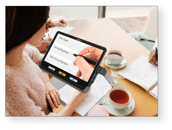 User completing a form using the explorē 12 electronic magnifier.